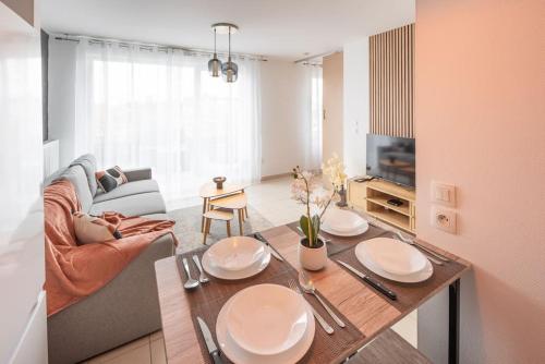 un salon avec une table et un canapé dans l'établissement L'excellence-8min Aéroport-terrasse-Parking Privé, à Lingolsheim