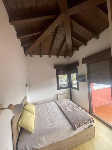 a bedroom with a bed and a large window at Villa Giraldillo in Colunga