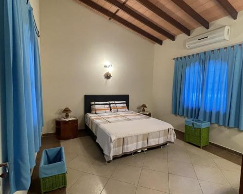 1 dormitorio con 1 cama grande y cortinas azules en Cozy & Relaxing Resort Oasis ~ Sports Field ~ Pool, en Luque