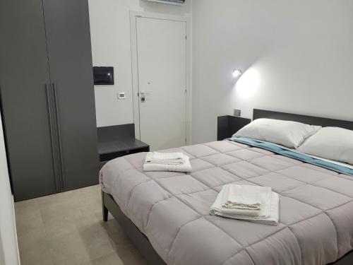 ein Schlafzimmer mit einem Bett mit zwei Handtüchern darauf in der Unterkunft Gemini rooms in Crotone