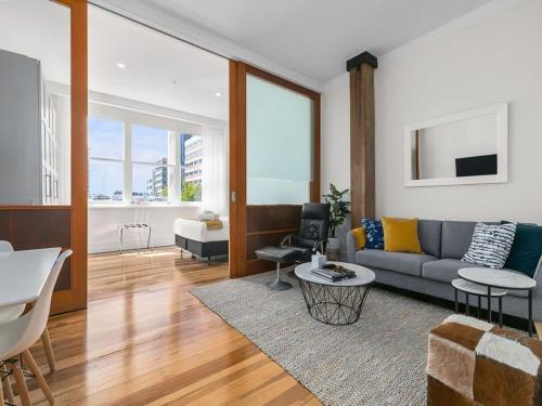 a living room with a couch and a table at 1BR CBD Escape Near Sky Tower Zodiak Stays in Auckland