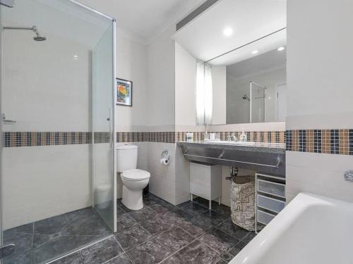 a bathroom with a toilet and a sink and a mirror at 1BR CBD Escape Near Sky Tower Zodiak Stays in Auckland