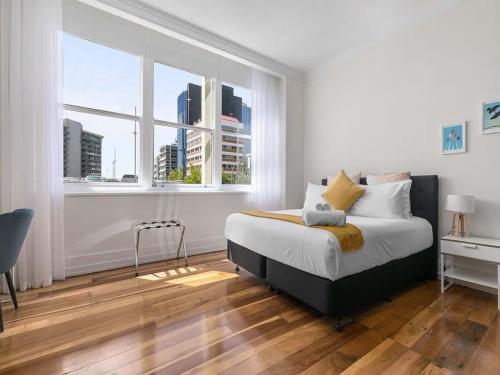 a bedroom with a bed and two large windows at 1BR CBD Escape Near Sky Tower Zodiak Stays in Auckland