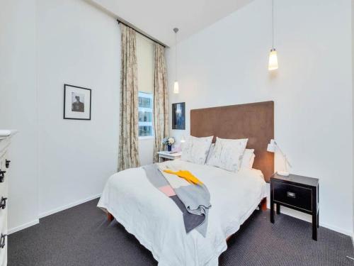 ein Schlafzimmer mit einem großen weißen Bett und einem Fenster in der Unterkunft Charming Spacious Two Bedroom in Central CBD in Auckland
