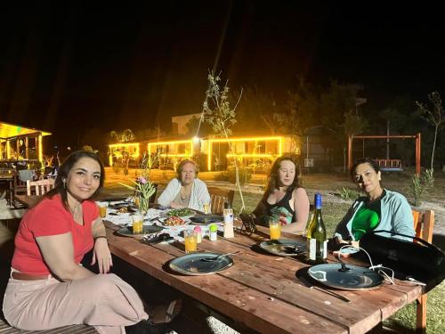 アドラサンにあるAdrasan Yıldız Bungalow Tatil Köyüの木製のテーブルに腰掛けた女性の集団
