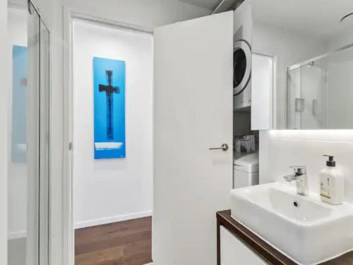 a bathroom with a sink and a cross on the wall at Two bedroom apartment - large balcony central in Auckland