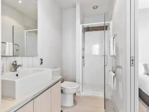 a bathroom with a sink and a toilet and a shower at Lovely and Cozy Apartment in Auckland in Auckland