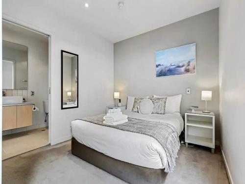 a bedroom with a large bed and a bathroom at Lovely and Cozy Apartment in Auckland in Auckland