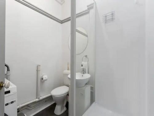 Baño blanco con aseo y lavamanos en Lovely 1-Bedroom Unit in Central Auckland en Auckland