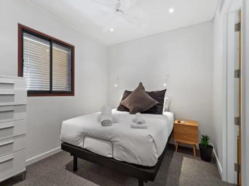 a bedroom with a bed with a dresser and a window at Lovely view apartment - free parking, pool and gym in Auckland