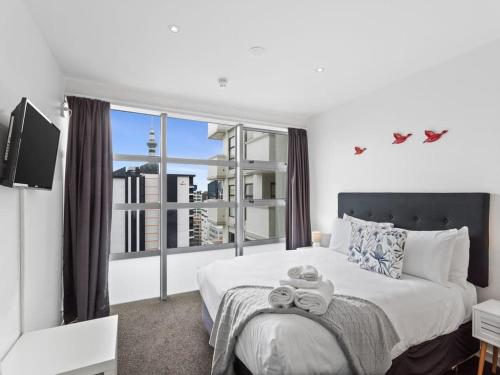 a bedroom with a bed and a large window at Central City 1BR Apartment in Auckland