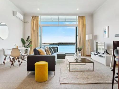 a living room with a view of the ocean at Relaxing Sea Wharf View Apartment by Zodiak Stays in Auckland