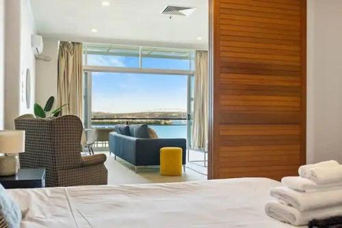a bedroom with a bed and a view of the ocean at Relaxing Sea Wharf View Apartment in Auckland