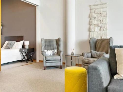 a living room with a couch and chairs and a bed at Relaxing Sea Wharf View Apartment by Zodiak Stays in Auckland