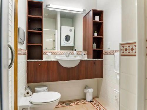 a bathroom with a sink and a toilet and a mirror at Relaxing Sea Wharf View Apartment in Auckland