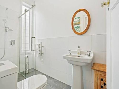 a bathroom with a sink and a toilet and a mirror at Cheerful 1 Bedroom Home with Free Parking in Auckland