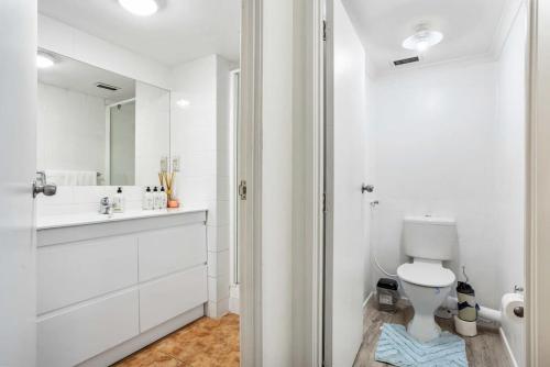 uma casa de banho branca com um WC e um lavatório em Lovely 2-Bedroom Apartment with Free Parking em Auckland