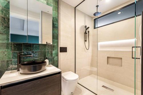 a bathroom with a toilet and a glass shower at Awesome Apartment w Parking in Auckland