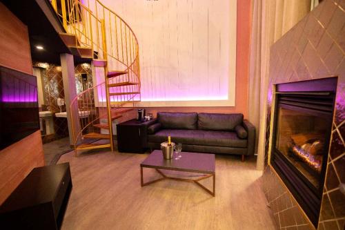 a living room with a couch and a fireplace at Hôtel Le Rivage in Rosemère