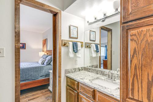 een badkamer met een wastafel, een spiegel en een bed bij Cozy Mtn Condo with Grill, 28 Mi to Wolf Creek! in Pagosa Springs