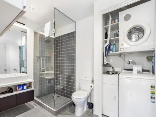 a bathroom with a toilet and a shower and a sink at Stunning Views of Viaduct Harbour Free Parking in Auckland