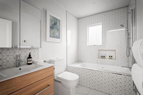 a bathroom with a toilet and a tub and a sink at Three-Bedroom Grey Lynn Villa in Auckland
