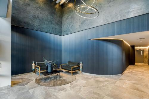 a lobby with a couch and a chair and a table at Modern Bright Central Apartment by Zodiak Stays in Auckland