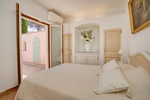 une chambre avec un grand lit blanc et une fenêtre dans l'établissement Maison de vacances face au golf de St-Maxime, à Sainte-Maxime