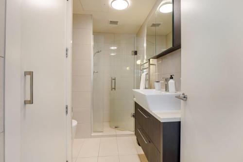 y baño con ducha y lavamanos. en Bright & modern Auckland CBD apartment, en Auckland