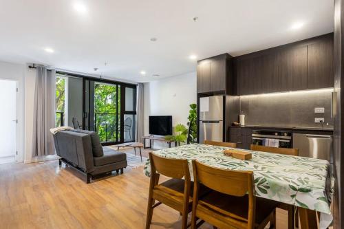 a kitchen and dining room with a table and chairs at Auckland City Charm - 2BR Haven by Zodiak Stays in Auckland