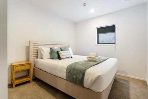 a bedroom with a large bed and a window at Auckland City Charm - 2BR Haven by Zodiak Stays in Auckland