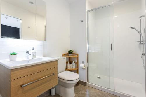 a bathroom with a toilet and a shower at Auckland City Charm - 2BR Haven by Zodiak Stays in Auckland