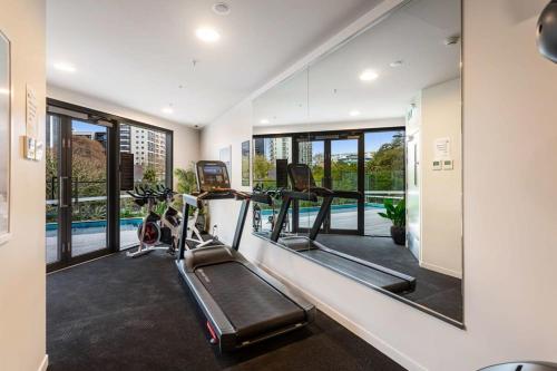 a gym with two tread machines and a mirror at Auckland City Charm - 2BR Haven by Zodiak Stays in Auckland