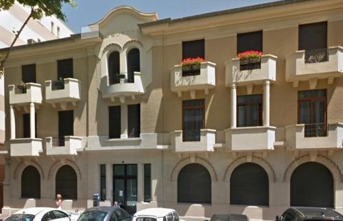 un grand bâtiment avec des voitures garées devant dans l'établissement COCON ART DECO - ARCACHON CENTRE & PLAGE - L'Europe, à Arcachon