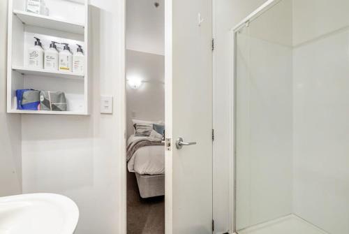 uma casa de banho com um WC e uma porta de vidro em Retro style on Queen Street em Auckland