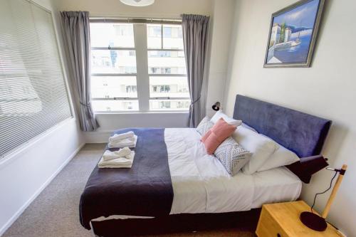 um quarto com uma cama grande e uma janela em Central Auckland 1-bedroom apartment em Auckland