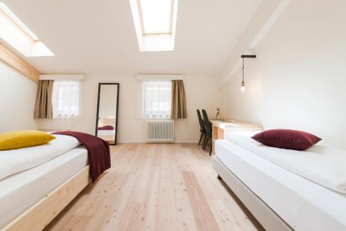 two beds in a room with a wooden floor at Zum Hirschen Boutique Hotel Val di Non in Unsere Liebe Frau im Walde