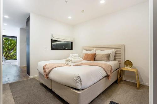 a bedroom with a large bed with a tv on the wall at Sunny 1BR Retreat in Heart of CBD by Zodiak Stays in Auckland