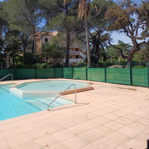 une piscine vide avec une clôture et des arbres dans l'établissement WEEK END A LA MER, à Fréjus