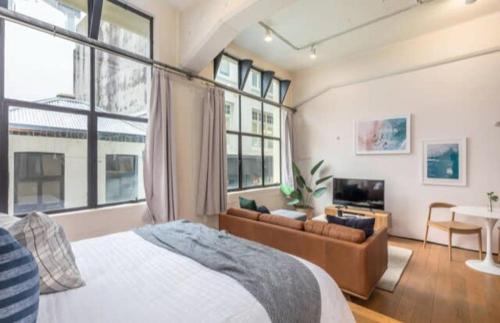 1 dormitorio con cama, sofá y mesa en Central stylish studio en Auckland