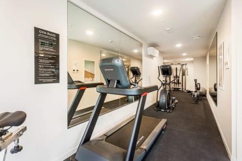 a gym with a treadmill and a mirror at Sunny 1BR Retreat in Heart of CBD by Zodiak Stays in Auckland