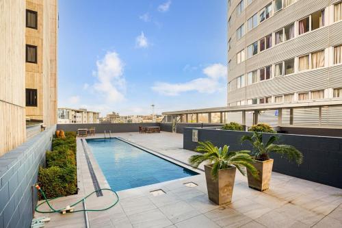 a swimming pool on the roof of a building at Downtown Auckland Bliss - 2BR apt I Zodiak Stays in Auckland