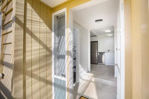 a hallway of a house with a staircase and a kitchen at Freshly renovated Grey Lynn 3BR unit in Auckland