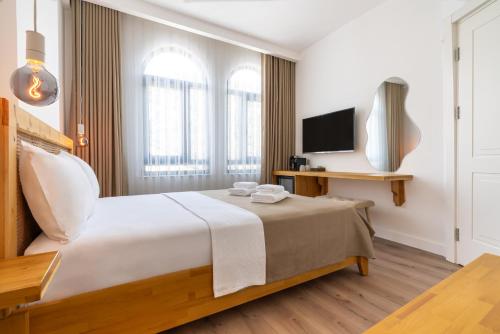 a hotel room with a bed and a television at Audo Local in Antalya
