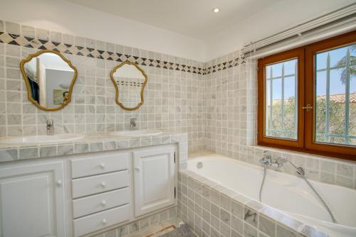 une salle de bain avec deux lavabos et une baignoire dans l'établissement Maison de vacances face au golf de St-Maxime, à Sainte-Maxime