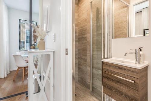 a bathroom with a sink and a shower at Fresh & sleek Grey Lynn unit with private patio in Auckland
