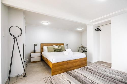 Dormitorio con cama con espejo y trípode en Stunning studio in Grey Lynn, en Auckland