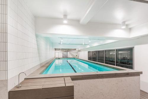 a large swimming pool in a building at Urban Escape Prime Location by Zodiak Stays in Auckland
