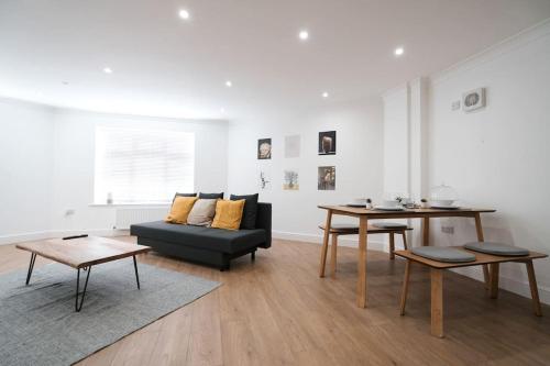 uma sala de estar com um sofá e uma mesa em Spacious 1 Bed with free parking in Hounslow em Hounslow