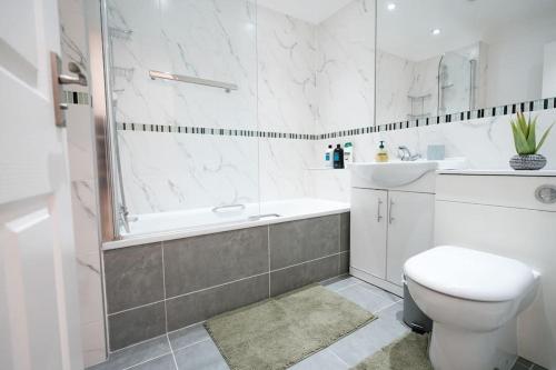 a bathroom with a toilet and a tub and a sink at Spacious 1 Bed with free parking in Hounslow in Hounslow